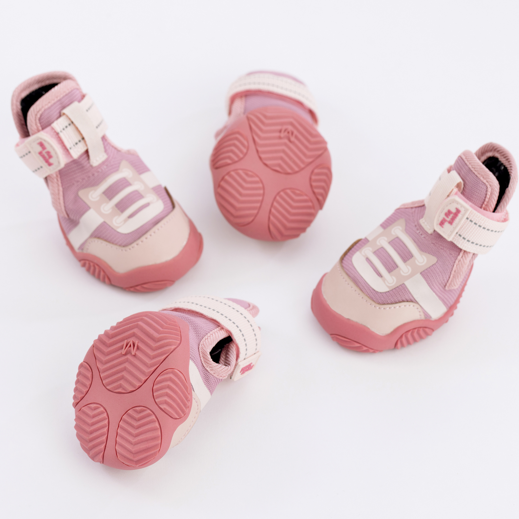 Pink dog sneakers with white lace detail and textured rubber soles