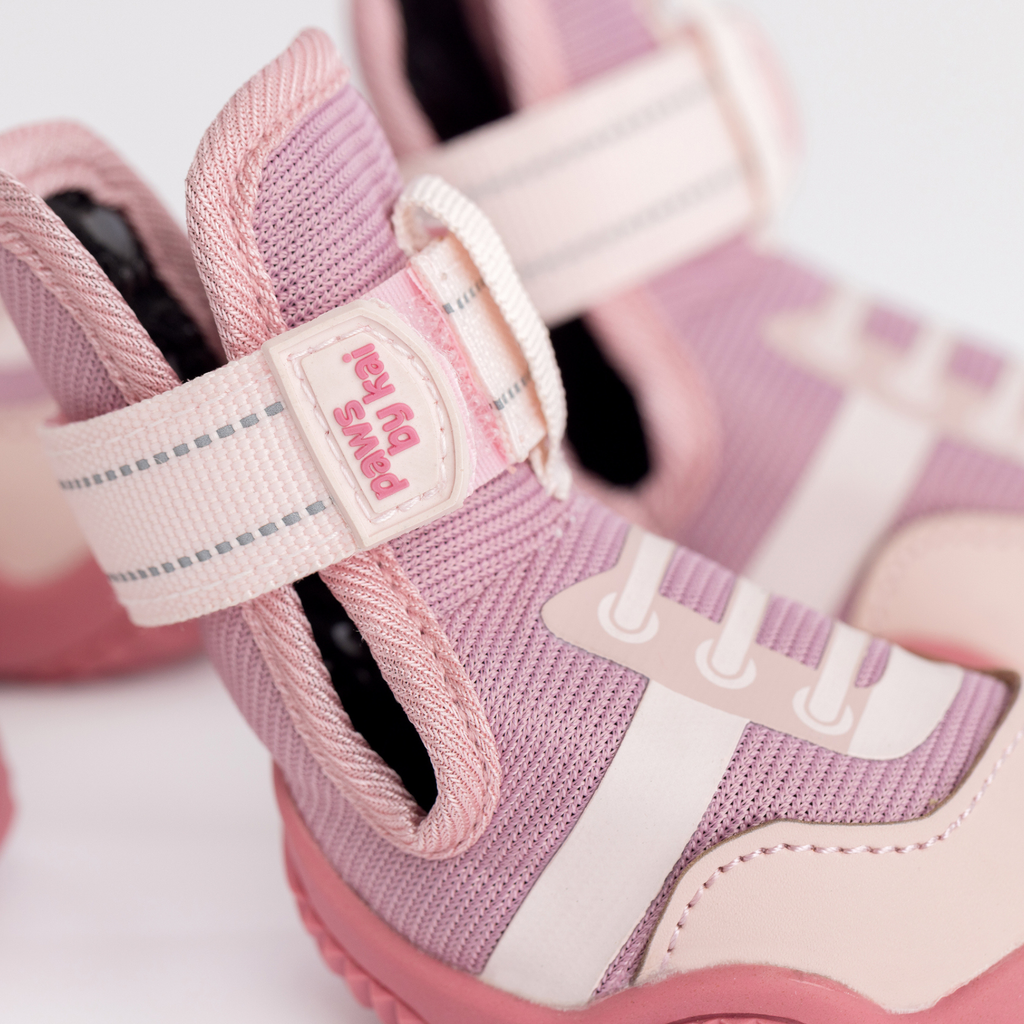 Pink and white hook-and-loop strap with logo patch on dog sneaker