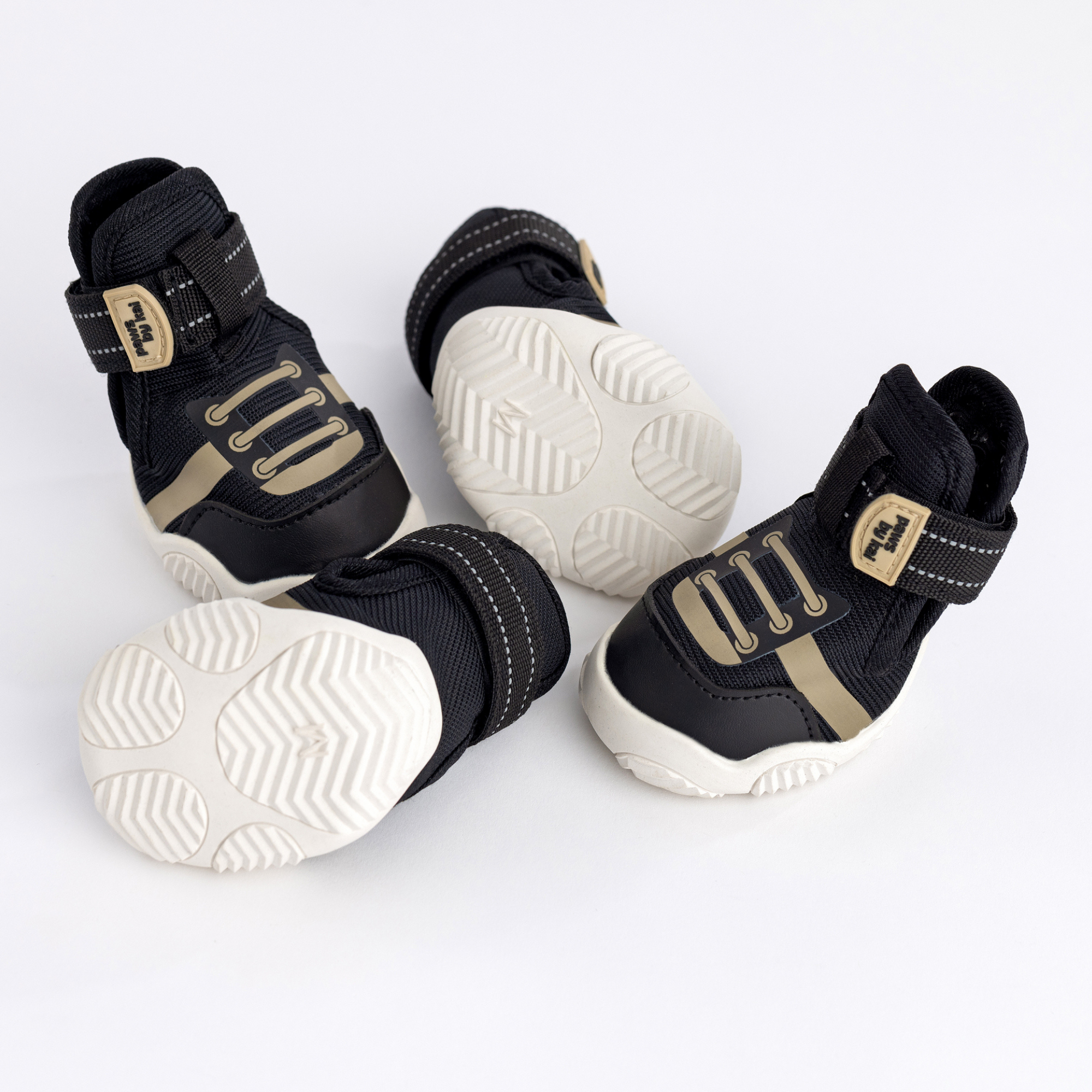 Black dog sneakers showing side, front, and outsole tread with hook-and-loop straps