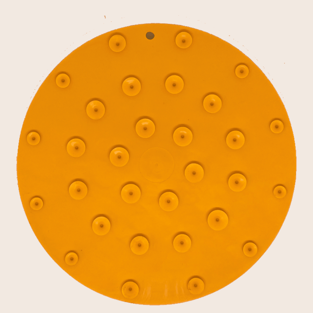 Orange circular dog lick mat with small suction cup bump dots and center circle