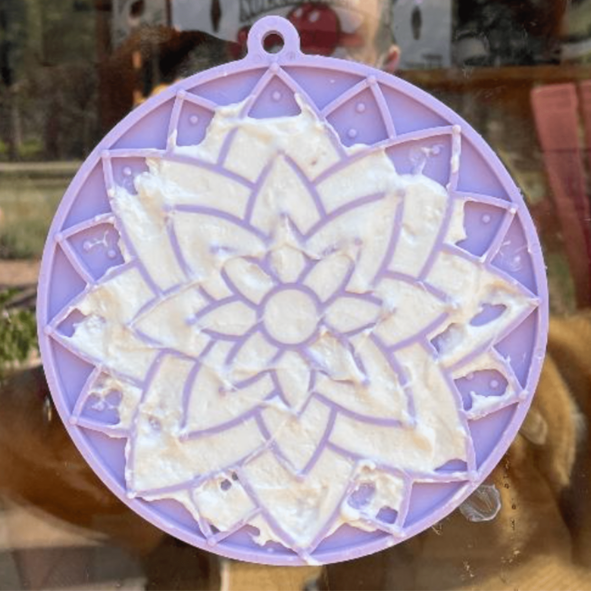 Lavender dog lick mat with raised swirls, filled with creamy treat spread.