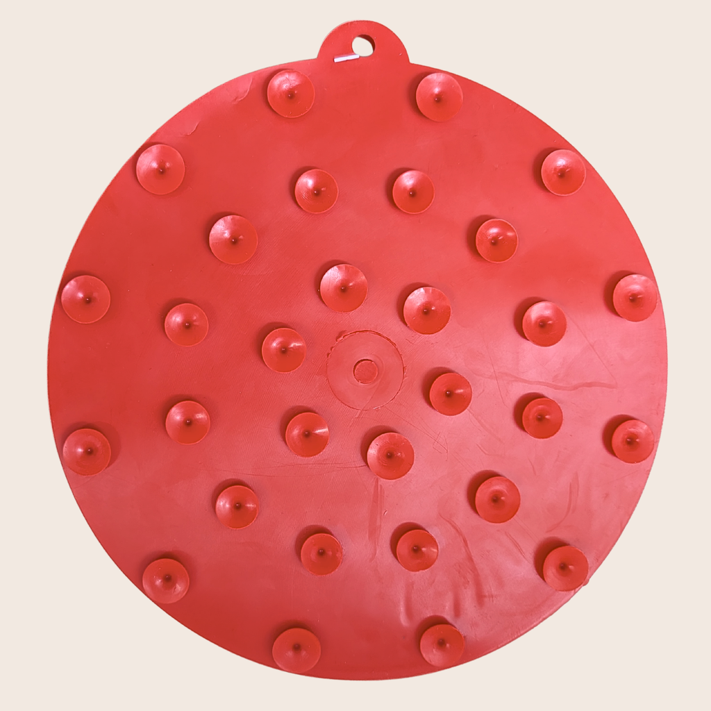 Red round dog lick mat with suction cup bumps and raised feeding dots