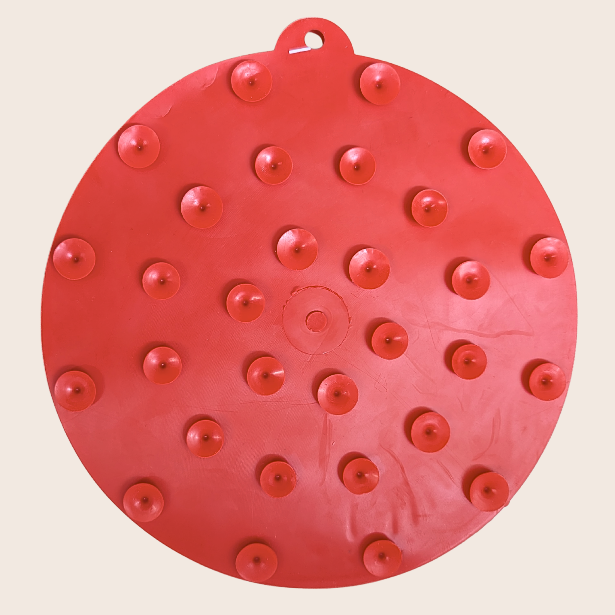 Red round dog lick mat with suction cup bumps and raised feeding dots