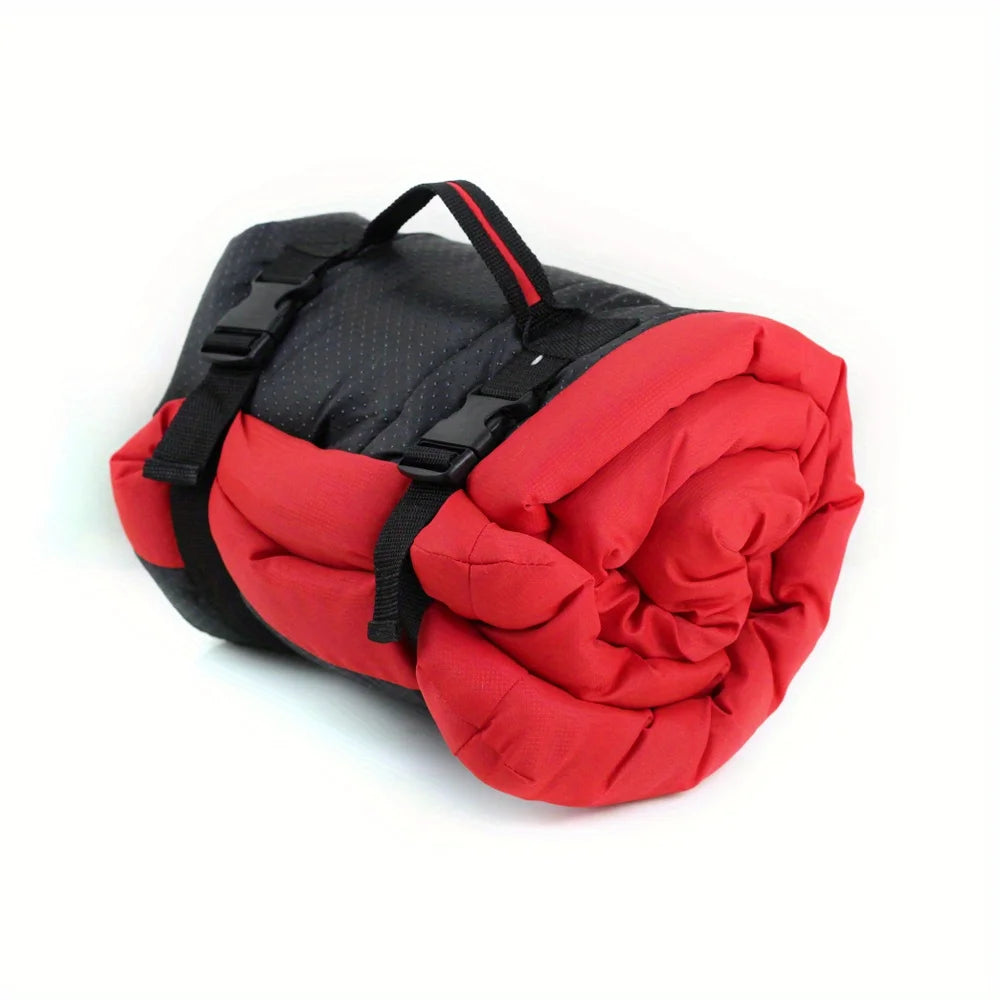Pet bed cushion in red, rolled up with black carry straps and red trim