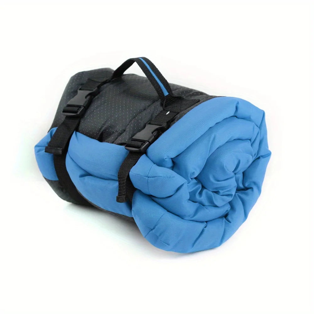 Pet bed cushion in blue, rolled up with black carry straps