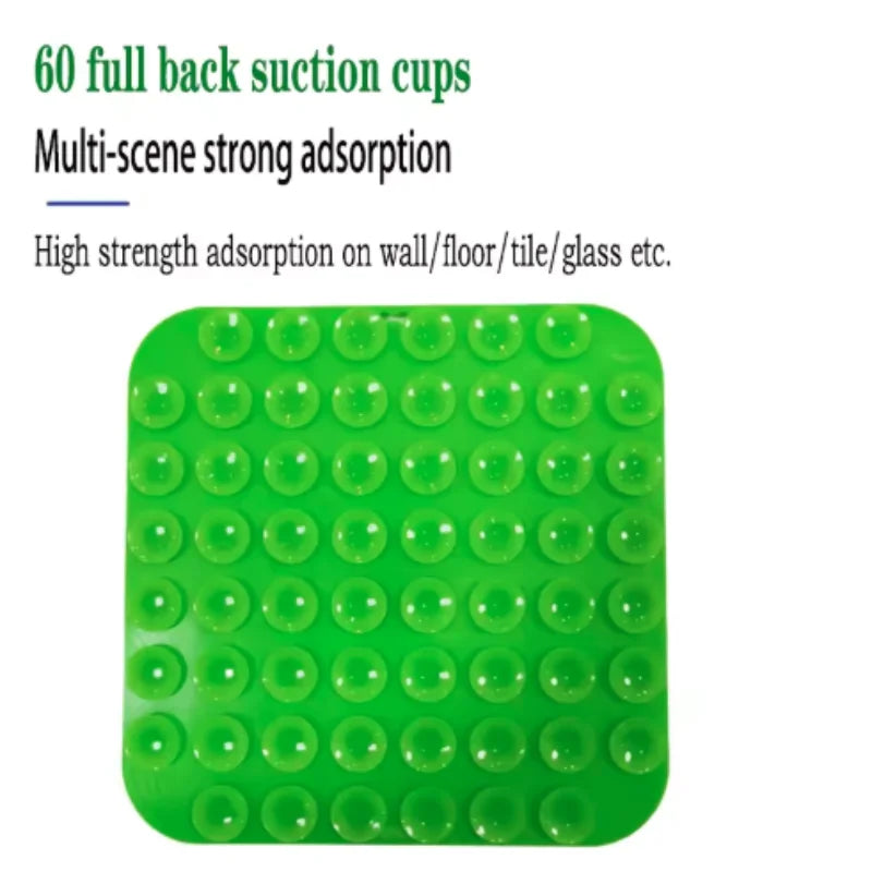 Green silicone lick mat with raised suction-cup dimples on a textured surface