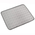 Light gray dog cooling mat with raised bubble pattern and dark border trim