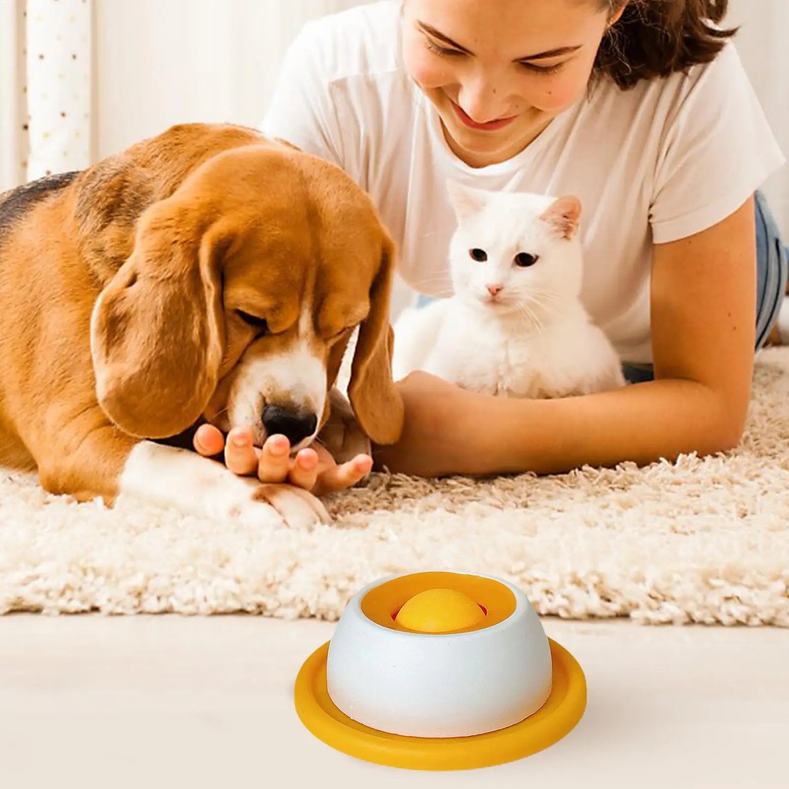 Slow feeder dog bowl with yellow base and white dome in front of a dog and cat