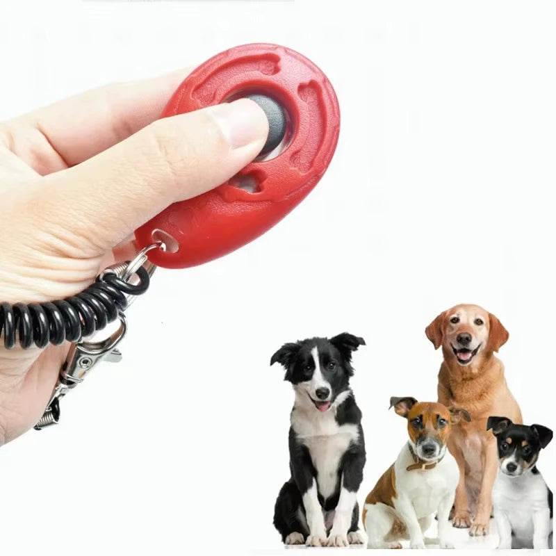 Red teardrop dog training clicker close-up with black coiled strap and metal hook