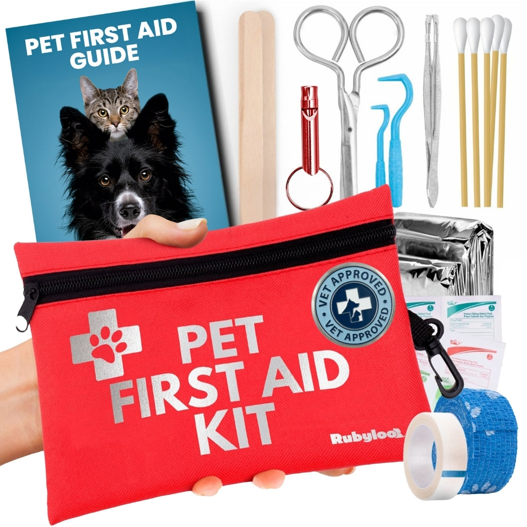 Red pet first aid kit pouch with white paw logo alongside tools, gauze, and a first aid guide