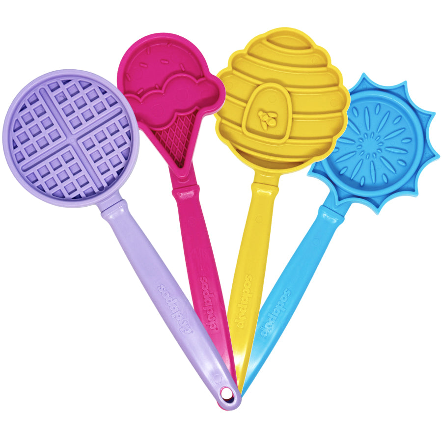 Set of four hand-held lick sticks: purple waffle, pink, yellow, and blue shapes