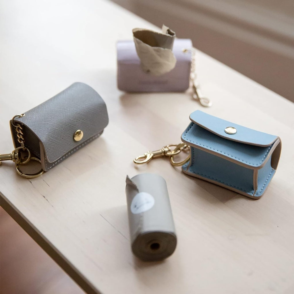 Dog waste bag rolls with dispenser pouches, gray roll with light-brown and blue pouches